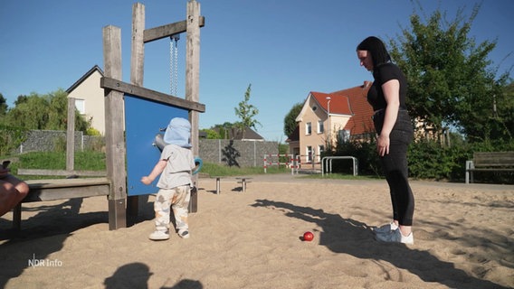 Eine junge Mutter mit ihrem Kind auf einem Spielplatz. © Screenshot 