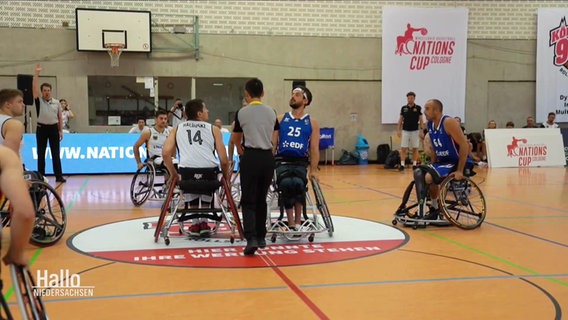 Paralympics-Basketballspieler versammeln sich auf dem Feld. © Screenshot 