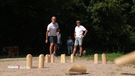 Ein paar Männer spielen Mölkky auf einem Feldweg. © Screenshot 