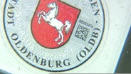 Wappen der Stadt Oldenburg auf dem Nummernschild eines Autos. © Screenshot 