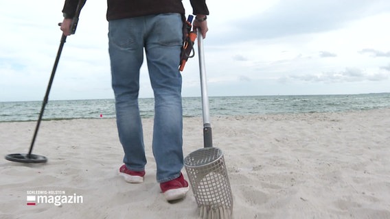 Eine Person mit Metalldetektor am Strand. © Screenshot 