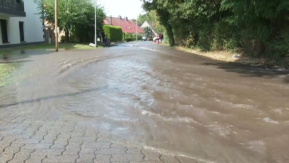 Wassermassen fließen über eine Straße. © Screenshot 