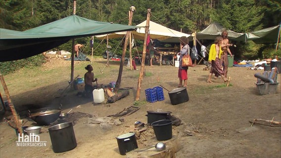 Mitglieder der "Rainbow Family" räumen ihr Sommercamp auf. © Screenshot 