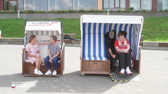 Ein Strandkorb mit Platz für einen Rollstuhl, neben einem altbekannten Strandkorb. © Screenshot 