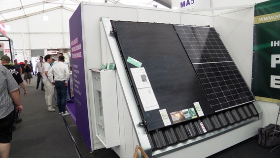 Solarpanel sind an einem Messestand ausgestellt. © Screenshot 