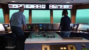 Zwei Personen in einem Containerschifffahrts-Simulator. © Screenshot 