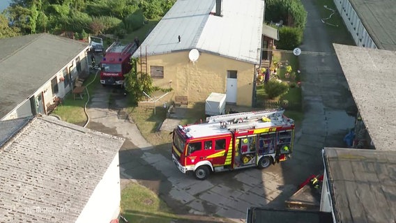 Ein Feuerwehrauto steht in der Mitte eines Gebäudekomplexes. © Screenshot 