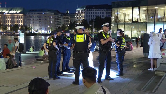 Der Jungfernstieg bei Nacht in Hamburg. Polizisten stehen im Einsatz bei einer Gruppe von Jugendlichen. © Screenshot 