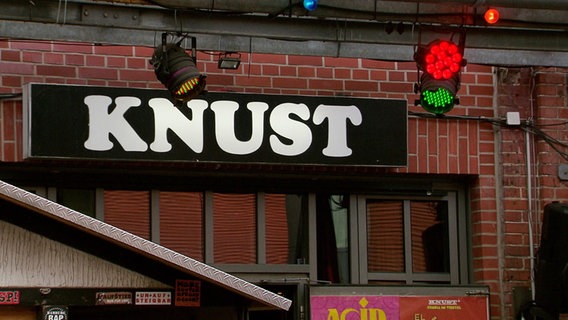 Blick auf die Fassade von einem Hamburger Club. Auf einem schwarzen Schild mit weißer Schrift steht "Knust". © Screenshot 