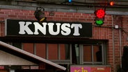 Blick auf die Fassade von einem Hamburger Club. Auf einem schwarzen Schild mit weißer Schrift steht "Knust". © Screenshot 