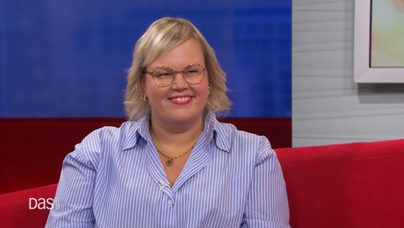 N-JOY Moderatorin und Comedienne Martina Schönherr bei DAS! auf dem Roten Sofa am 07.09.2024. Sie ist eine Frau mit vollem Gesicht und trägt kinnlange, blonde Haare. © Screenshot 