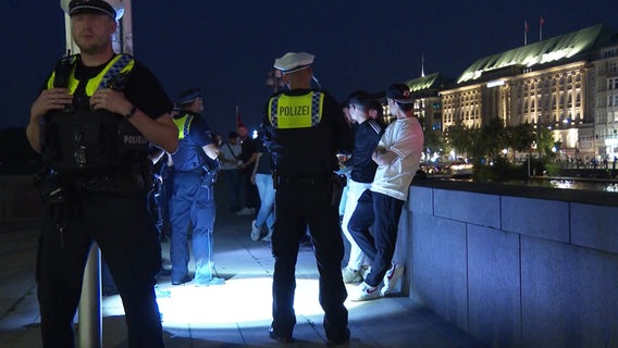 Polizisten führen Personenkontrollen am Jungfernstieg durch. © Screenshot 