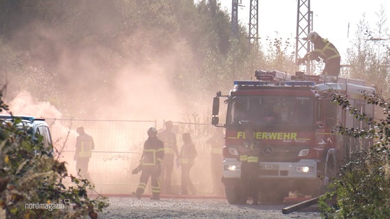 In der Ferne simulieren Einsatzkräfte der Feuerwehr einen Waldbrand mit großer Nebelwolke. © Screenshot 