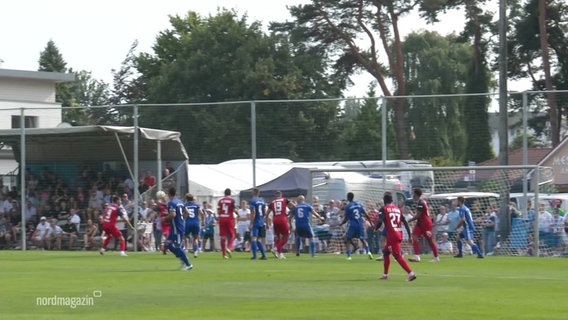 Fußballspieler laufen auf einem Platz bei einer Torszene. © Screenshot 