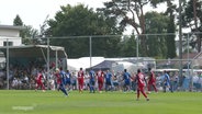 Fußballspieler laufen auf einem Platz bei einer Torszene. © Screenshot 