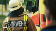 Eine Person in Arbeitskleidung der Feuerwehr, von hinten zu sehen. © Screenshot 