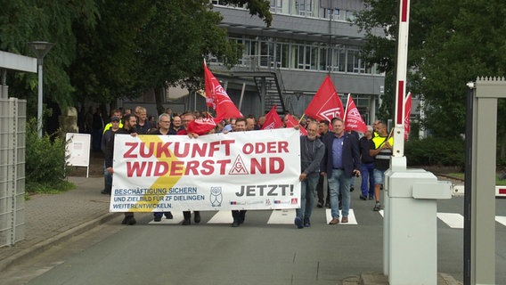 Mitarbeitende eines Autozulieferes protestieren an einem Werktor. © Screenshot 