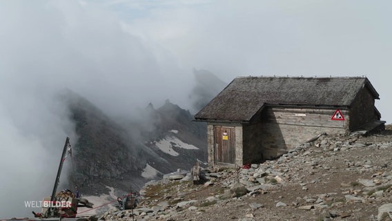 Eine Alpenhütte ist von Nebel umwoben. © Screenshot 