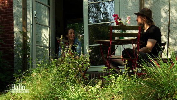 Ein Mann und eine Frau sitzen in einem Garten © Screenshot 