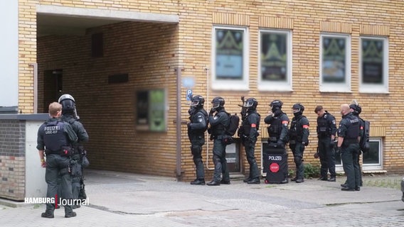 Spezialkräfte der Polizei positionieren sich vor einem Gebäde in Barmbek. © Screenshot 