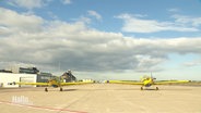 Zwei Löschflugzeuge stehen auf einem Flugplatz. © Screenshot 