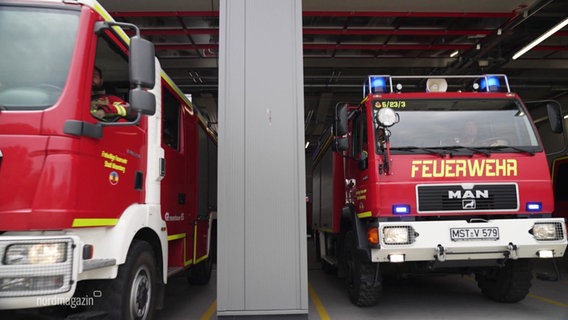 Zwei Löschfahrzeuge fahren aus der Wache einer Feuerwehr. © Screenshot 