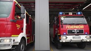 Zwei Löschfahrzeuge fahren aus der Wache einer Feuerwehr. © Screenshot 