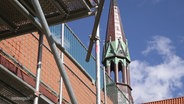 Im Vordergrund ein Baugerüst, im Hintergrund ein Turm der Klosterkirche in Neukloster. © Screenshot 