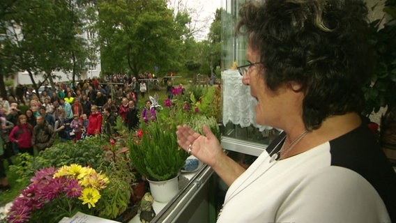 Eine Frau singt auf einem Balkon im Greifswalder Stadtteil Schönwalde II. © Screenshot 