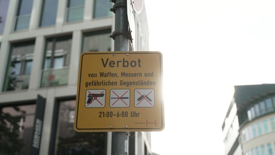 Ein gelbes Schild auf dem auf ein Waffenverbot hingewiesen wird. © Screenshot 