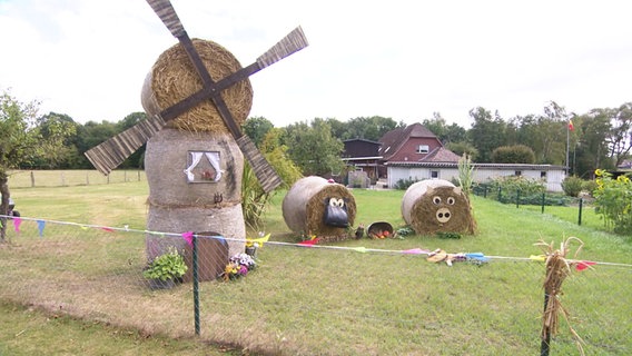 Dekorierte Heuballen stehen in einem Vorgarten. © Screenshot 