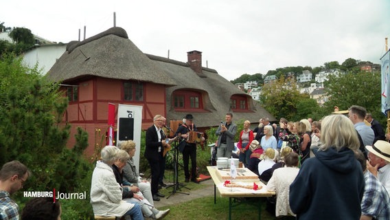 Vor dem Blankeneser Fischerhaus findet anlässlich dessen Wiedereröffnung eine Feier statt. © Screenshot 