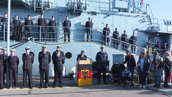 Marinesoldat:innen stehen stramm vor einem Schiff. © Screenshot 