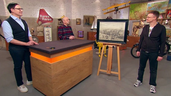 Der Kunsthistoriker Colmar Schulte-Goltz, Tv-Moderator Horst Lichter und Flohmarktfan Sebastian Hartung in der Sendung "Bares für Rares". © Screenshot 