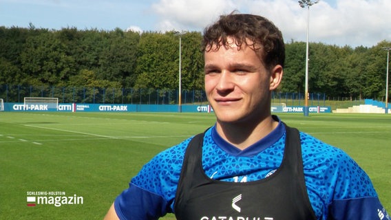 Ein Fußballspieler von Holstein Kiel auf einem Spielfeld. © Screenshot 