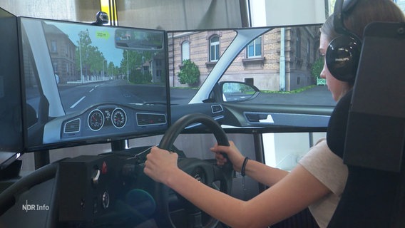 Eine Fahrschülerin trainiert an einem Simulator. © Screenshot 