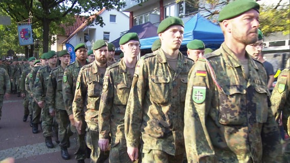 Soldaten marschieren im Gleichschritt durch eine Fußgängerzone. © Screenshot 