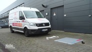 Vor einem weißen Sprinter befindet sich eine graue Platte am Boden, davor ein Ladesymbol für E-Autos. © Screenshot 