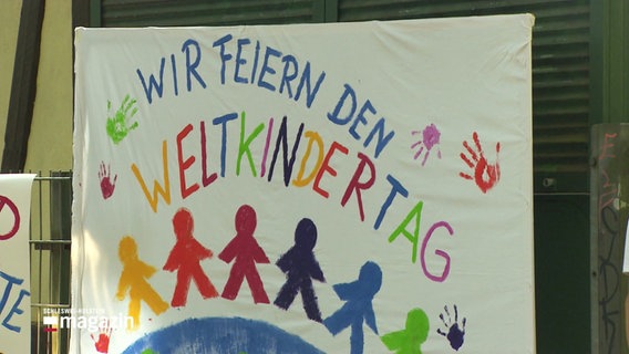 "Wir feiern den Weltkindertag", steht auf einem farbigen Banner geschrieben. © Screenshot 