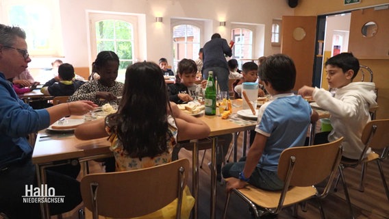 Kinder sitzen beim Mittagessen in Langenhagen. © Screenshot 