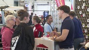 Mehrere Personen kommen bei der Jobmesse ins Gespräch. © Screenshot 