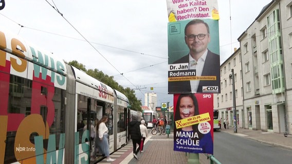 Mehrere Wahlplakate verschiedener Parteien an einer Straßenbahnhaltestelle. © Screenshot 