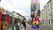 Mehrere Wahlplakate verschiedener Parteien an einer Straßenbahnhaltestelle. © Screenshot 