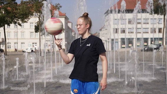 Die Fußball-Freestylerin Jule Pape balanciert einen Fußball auf einem Finger. © Screenshot 