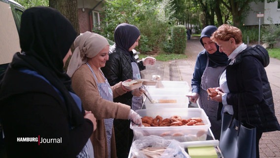 Frauen des Korallus Kitchen Mobil geben Essen aus. © Screenshot 