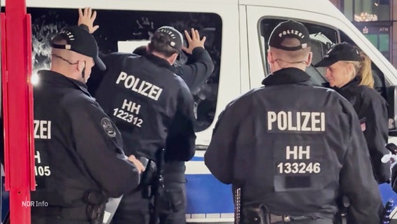 Polizeibeamte durchsuchen einen Fußballfan. © Screenshot 