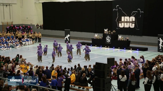 Tänzer:innen der "Just Dance Competition" in Aktion in einer großen Halle. © Screenshot 