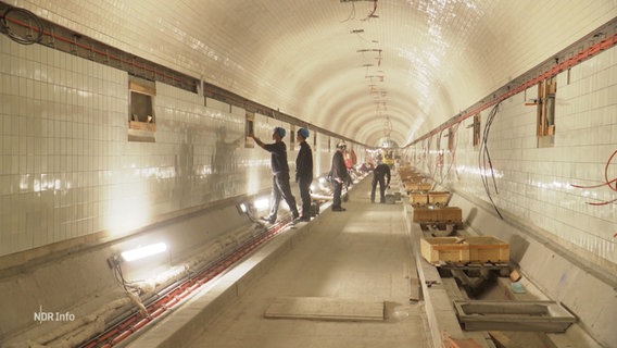 Blick in den alten Elbtunnel zeigt Bauarbeiter bei Sanierungsarbeiten. © Screenshot 