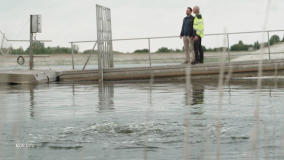 Zwei Männer stehen an einem Wasserspeicher. © Screenshot 