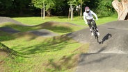 Ein BMX-Fahrer testet die neue Pumptrack-Fahrbahn. © Screenshot 